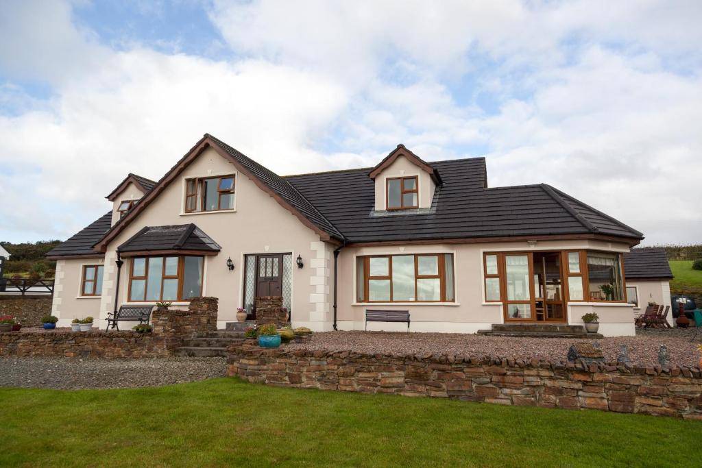 una casa blanca con techo negro en Inishowen Lodge B&B, en Moville