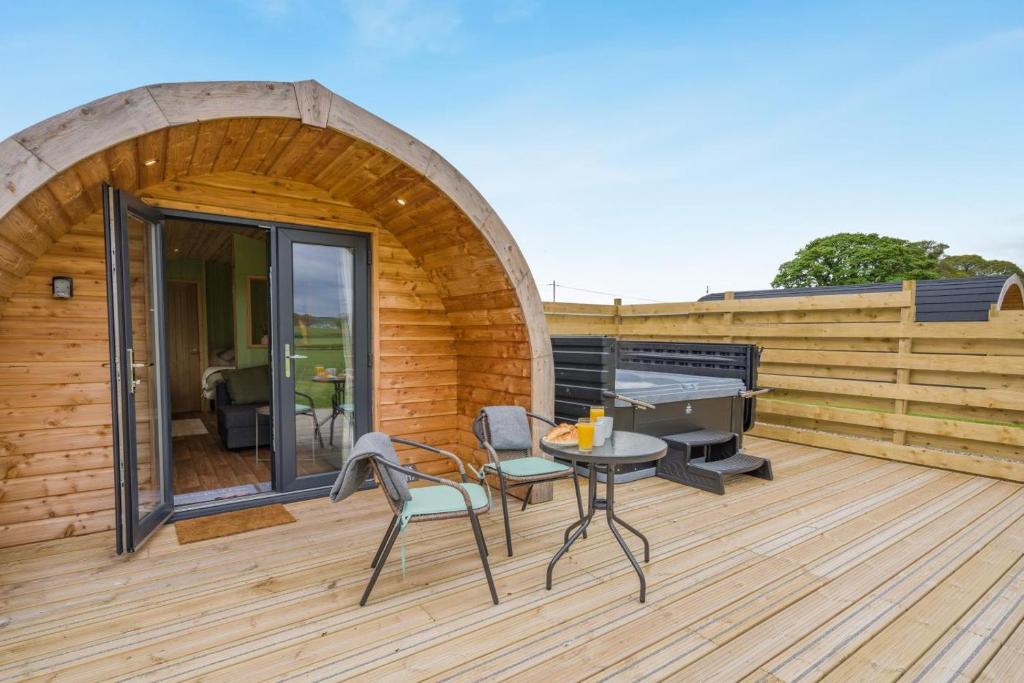 a wooden deck with a table and chairs on it at 1 Bed in Blairdrummond oc-b37875 in Doune