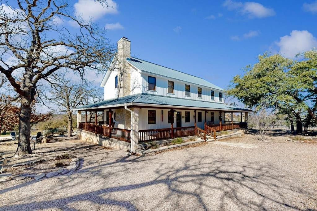 a large white house sitting on top of a field at Peaceful Home with Fire Pit, Gazebo, Patio, & Amazing Deck Views - Dog-Friendly in Fredericksburg