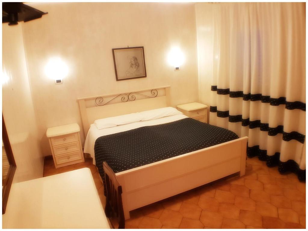 um pequeno quarto com uma cama e cortinas em Hotel Pisani em Taranto