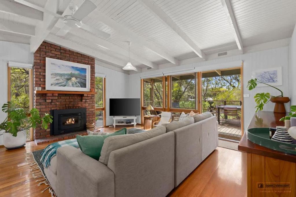 a living room with a couch and a fireplace at A charming escape from everyday life in Aireys Inlet