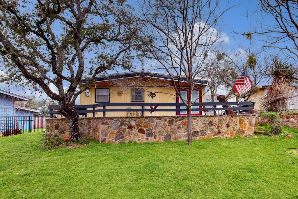 a house with a flag on top of a stone wall at Cozy Dog-Friendly House Near Water with Enclosed Yard, Grill, & Equipped Kitchen in Burnet