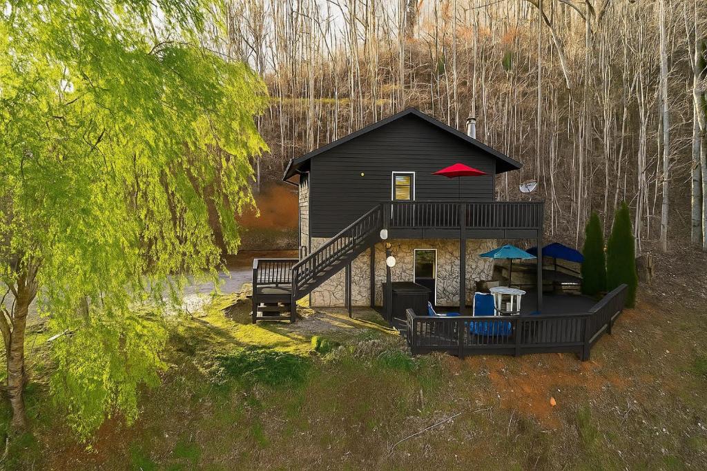 a cabin in the woods with a red roof at Edge View Chalet in Bryson City