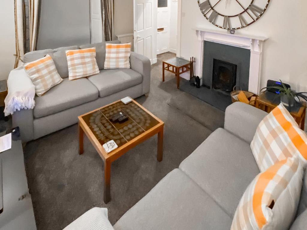 a living room with a couch and a coffee table at Elizabeth Lodge - Cottage in Alford