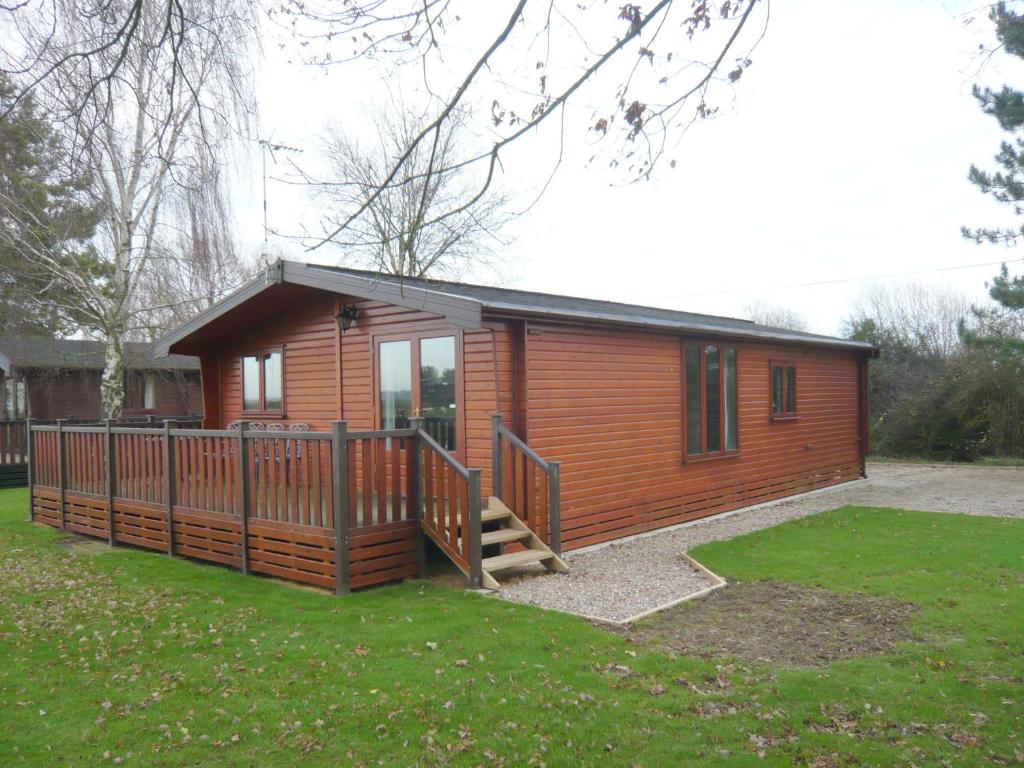 a small cabin with a porch and a deck at Charming Cottage in Romney Marsh Britain with Wooden Deck in Ivychurch