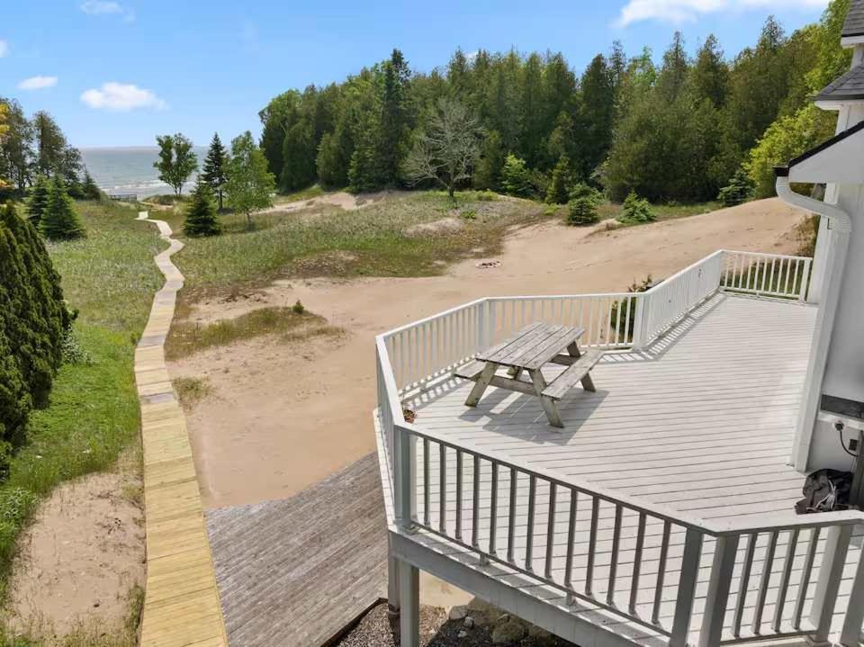 a deck with a bench on the side of a house at Dune Alright by Simple Life Rentals in Baileys Harbor