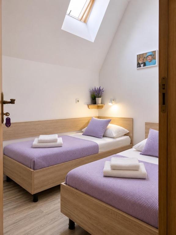 two beds in a room with purple sheets at Svit home Hamster 007- apart-hotel in Lviv