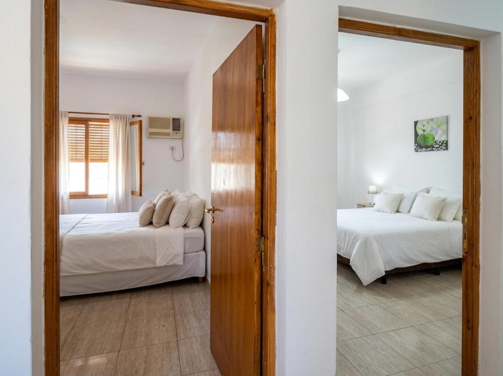 a bedroom with two beds and a mirror at Departamentos Marconi 1B in Resistencia