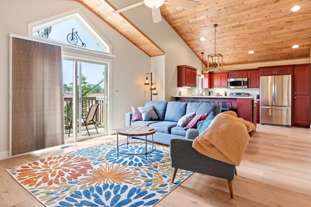 a living room with a blue couch and a kitchen at Upper Deck by Simple Life Rentals in Sturgeon Bay