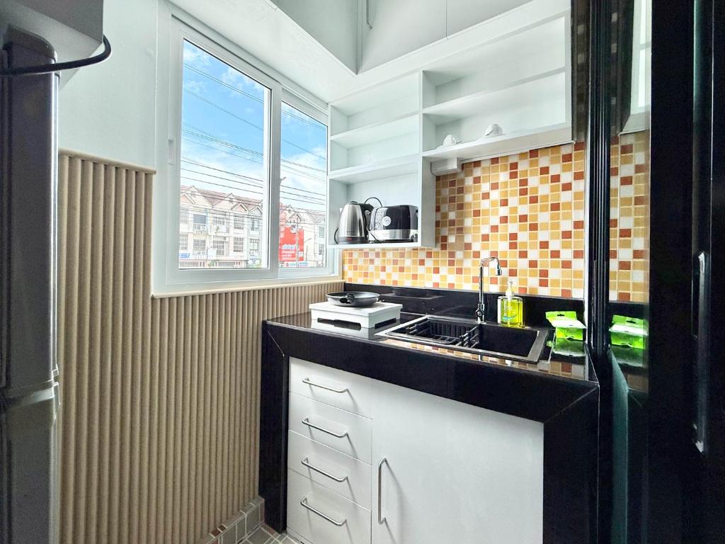 a kitchen with a sink and a counter top at Chalong - Studio Service Apartment - Phoomjai in Ban Klang