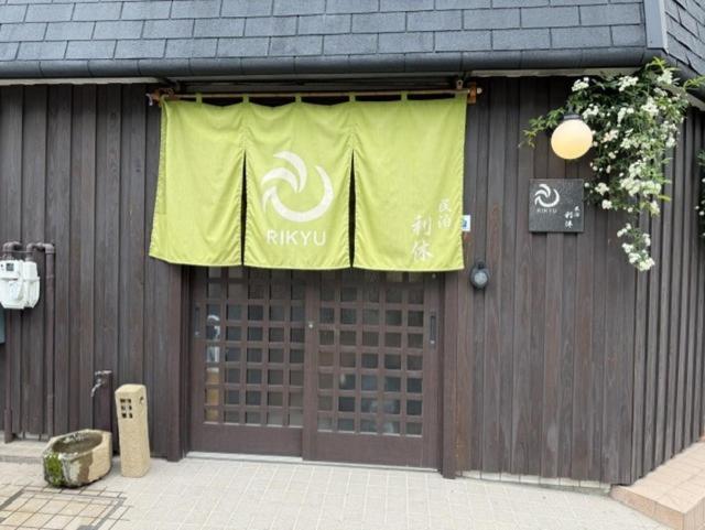 a building with a yellow banner on the side of it at 民泊利休 in Sakai