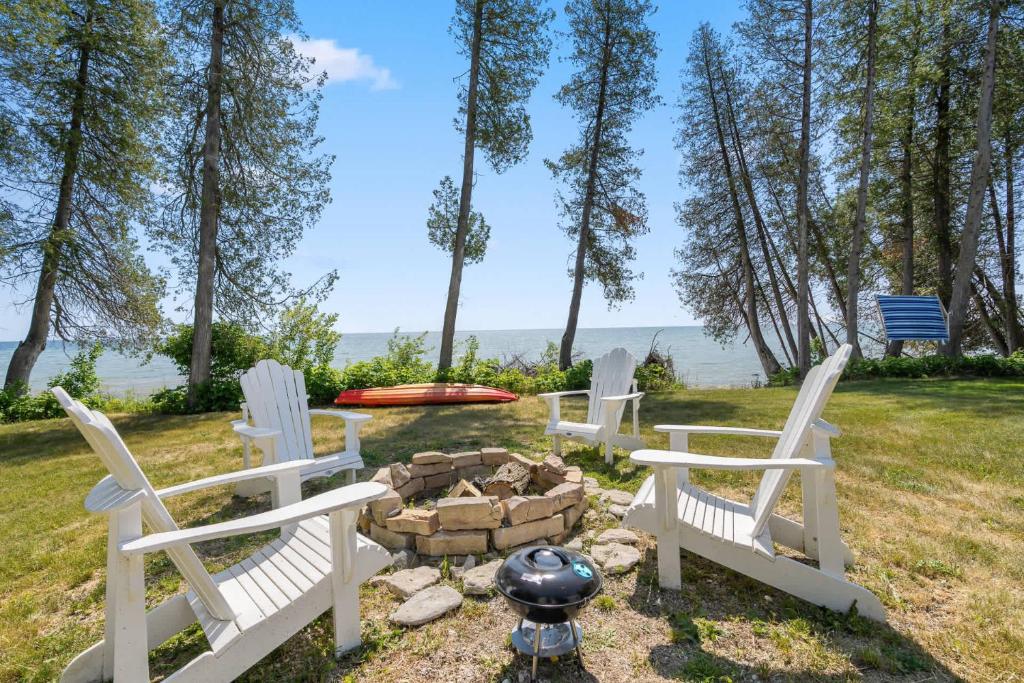 a group of chairs sitting around a fire pit at Tranquility Bay Getaway by Simple Life Rentals in Sister Bay