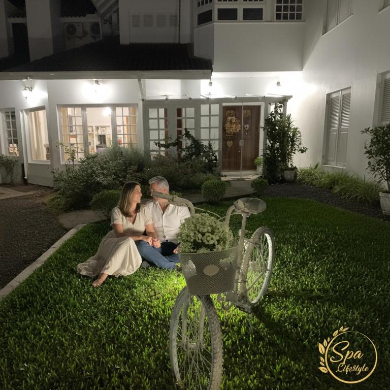 a man and woman sitting on the grass in front of a house at SPA LIFESTYLE Centro de Bem Estar in Canela