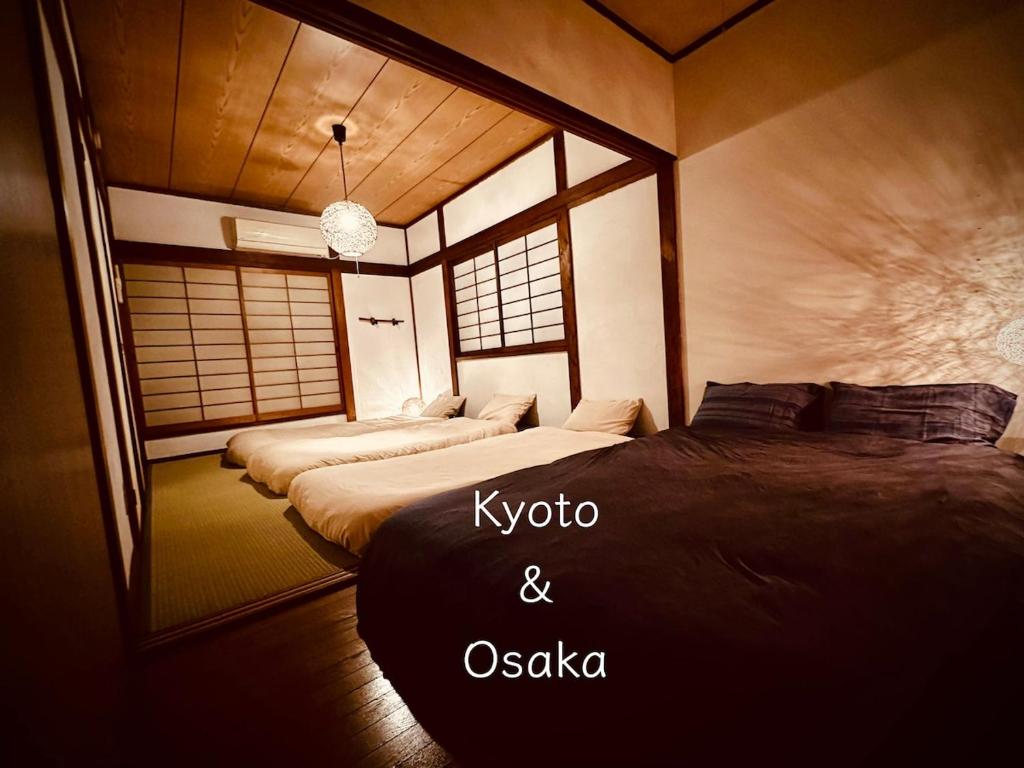 a room with two beds and a mirror at Between Kyoto & Osaka 渚南 駅徒歩3分 in Hirakata