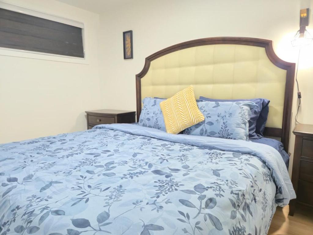 a bedroom with a blue and white bed with pillows at Edmonton Basement 1 KB 1 SB 3 Guest in Edmonton