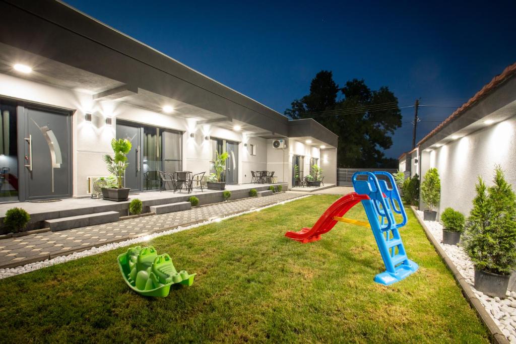 a house with a slide in the yard at Sofia Luxury Apartments in Gevgelija