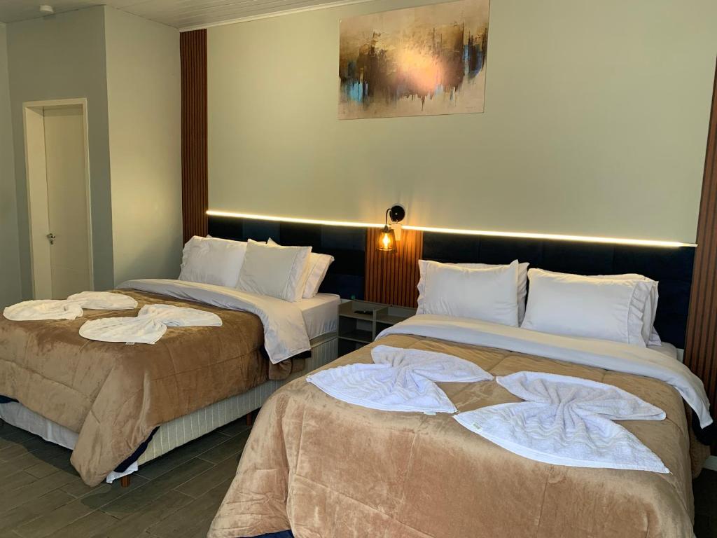 two beds sitting next to each other in a room at Pousada HG -101-Suíte in Vila Nova do Sul