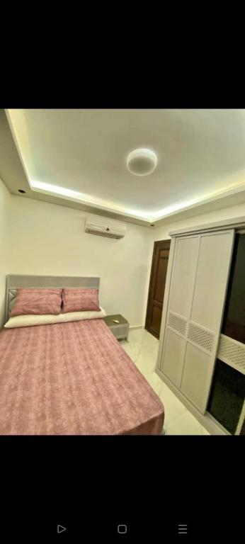 a bedroom with a bed with a pink blanket at بورتو جولف in El Dab‘a