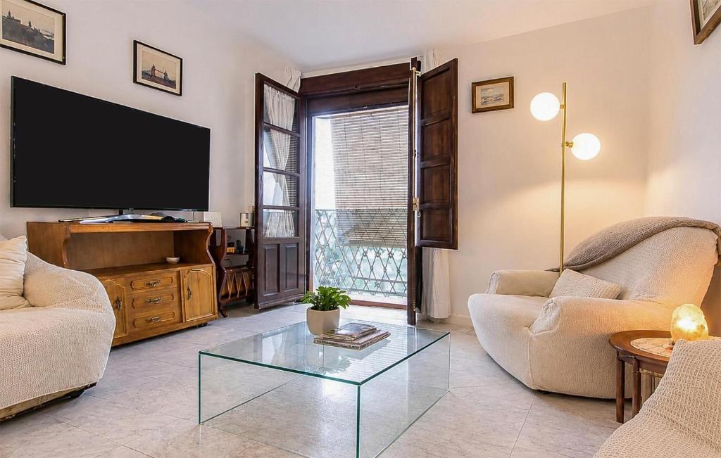 a living room with a tv and a glass coffee table at Casa Del Arco in Ronda