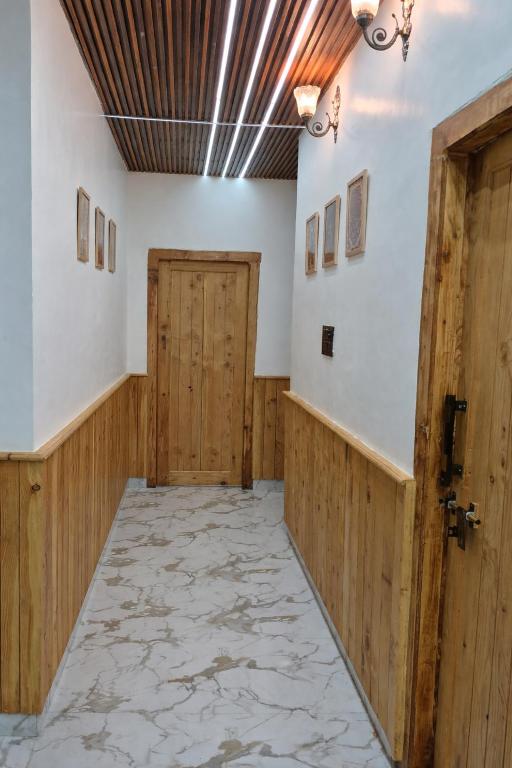 an empty hallway with wooden walls and a door at Ivory Nest Villa in Chamba