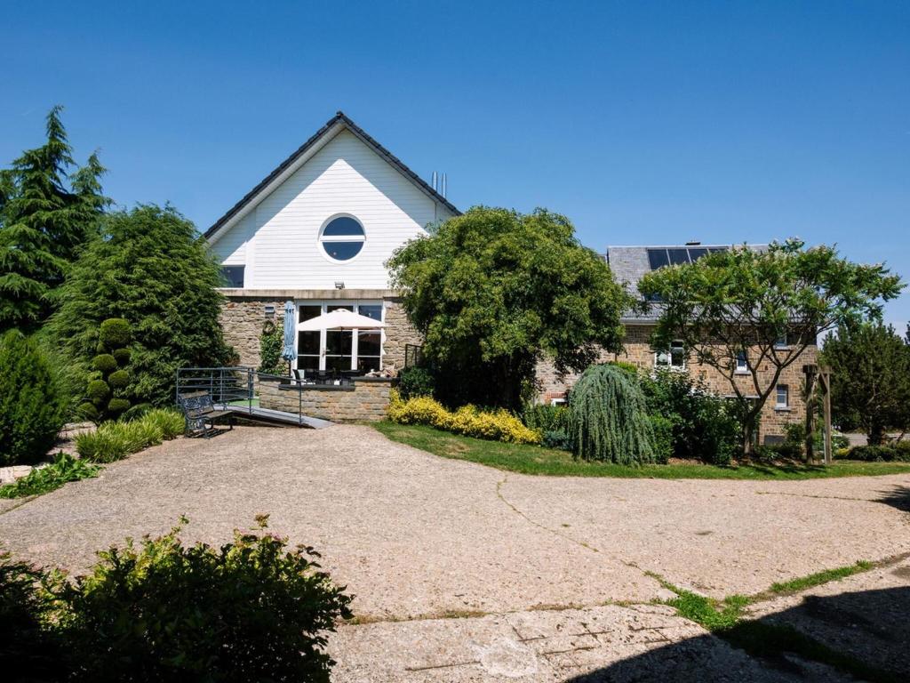 a house with a gravel driveway in front of it at Moderscheid Cottage with Spa in Amblève