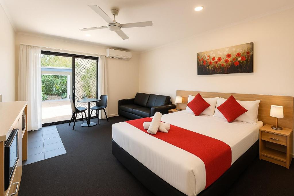 a hotel room with a bed and a chair at Abode37 Motel Emerald in Emerald