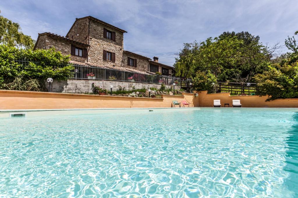 a large swimming pool in front of a house at Casolare Santa Margherita in Assisi