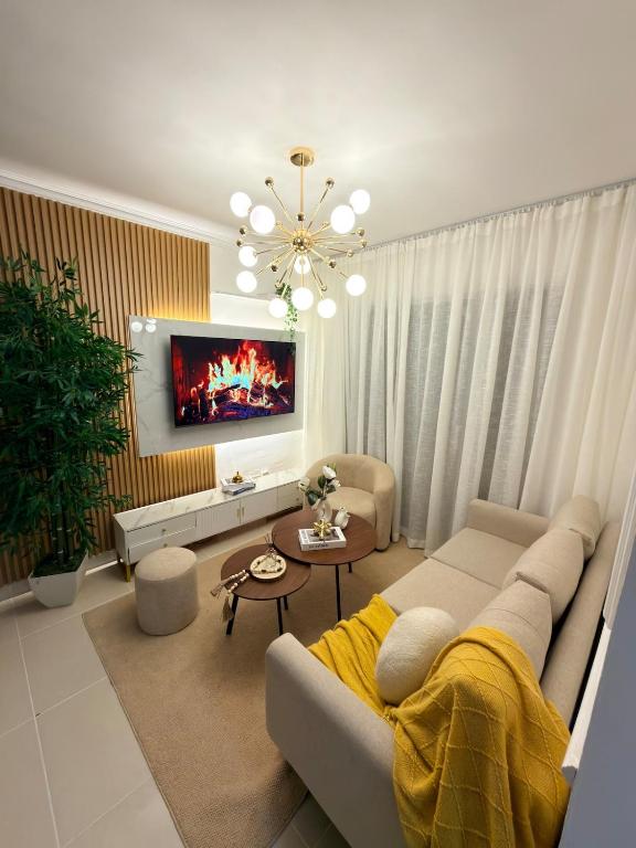 a living room with a couch and a tv at Comfort Home in La Cana