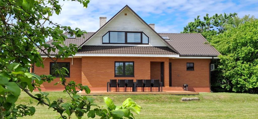 a house with black chairs in front of it at Sinilille 5 Holiday Home in Kuressaare