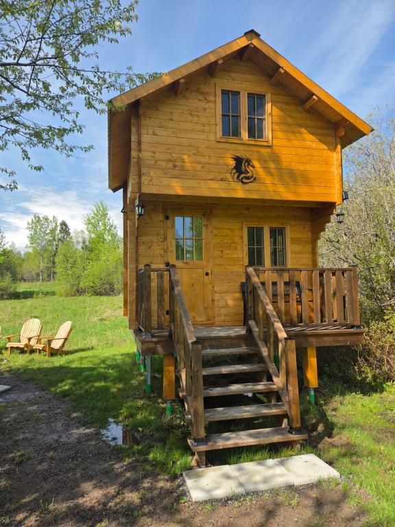 a log cabin with a staircase leading up to it at #3 La Maison du Dragon in Saint-Onésime