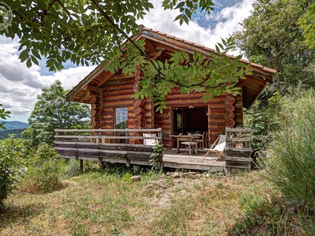 a log cabin with a deck and a table at Chalet chaud, nature sauvage, internet PC, idéal randonnées - FR-1-496-184 in Saint-Martin-la-Sauveté