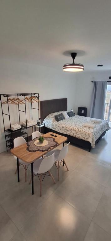 a bedroom with a bed and a table and chairs at Portales del Vino 2 in Tupungato