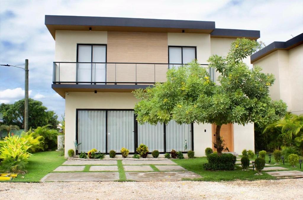a house with a balcony and a tree at Villa Divina in Punta Cana