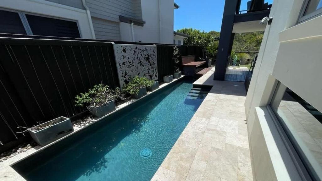 a swimming pool in the yard of a house at Green House in Marcoola