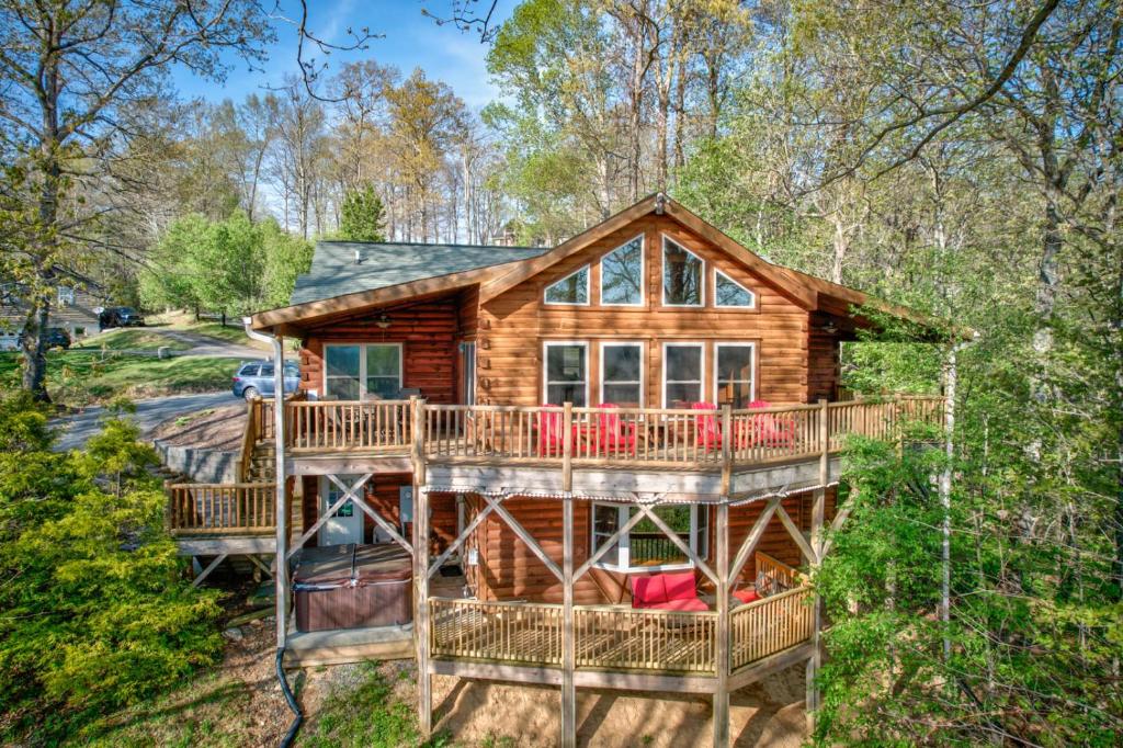 a log cabin in the woods with a large deck at Chestnut Lodge in Boone