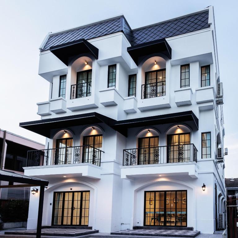 a white building with a black roof at Casa Luna in Bangkok