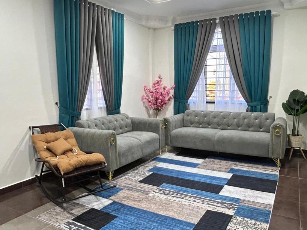 a living room with a couch and a chair at Zinirah Homestay in Tumpat