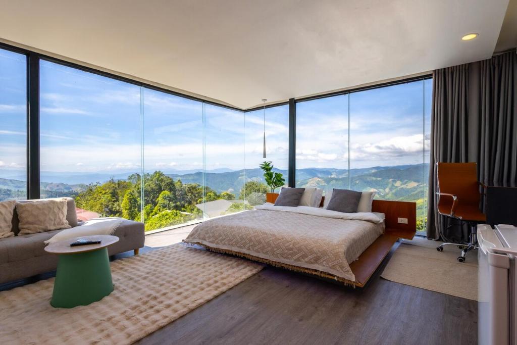 a bedroom with a bed and a couch and large windows at Sky Sakad Sunset at Doi Sakad, Nan in Ban Pha Hu