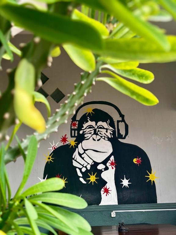 a picture of a monkey with headphones on a wall at Zzz Ijen Hostel in Banyuwangi