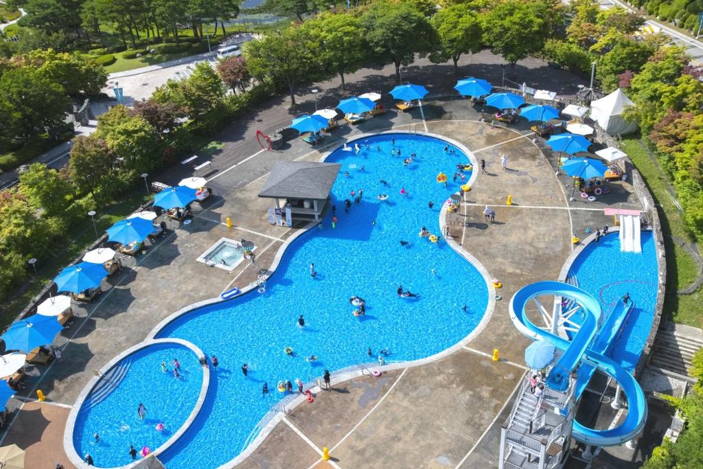 an overhead view of a water park with two pools and umbrellas at Elysian Gangchon Resort in Chuncheon