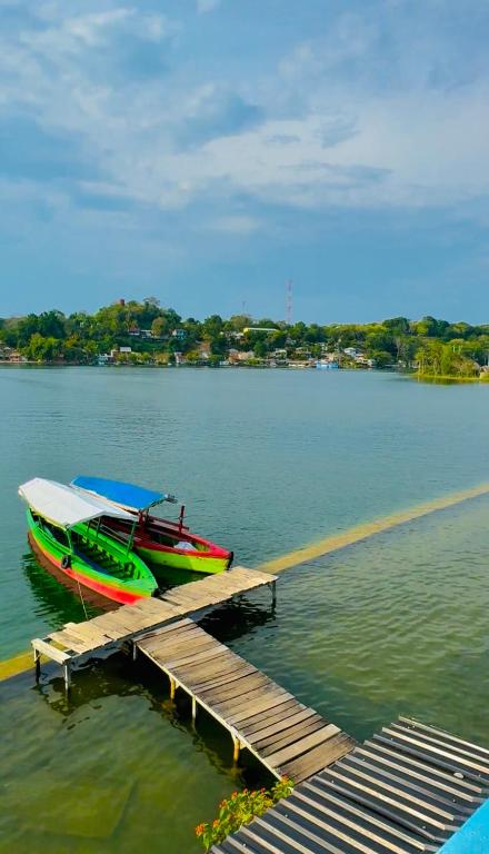 two boats are docked at a dock on a lake at Maple Guest House in Flores