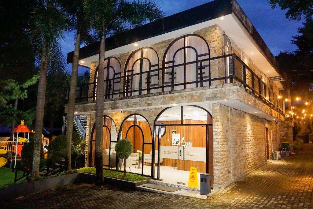 a large brick building with large windows at night at Nimo Resort Ciater in Ciater