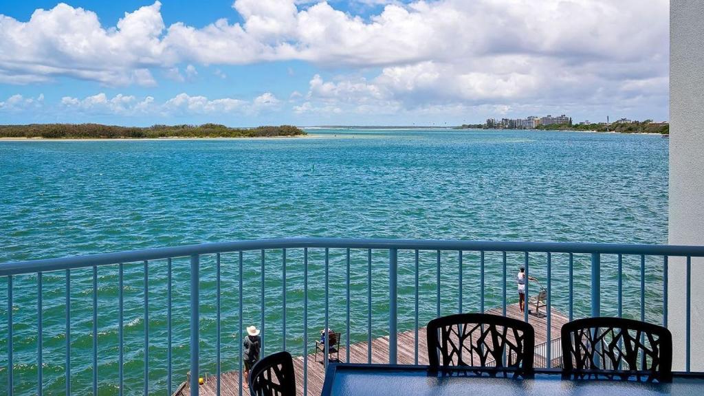 a balcony with chairs and a view of the water at Tripcony Quays Unit 11 in Caloundra
