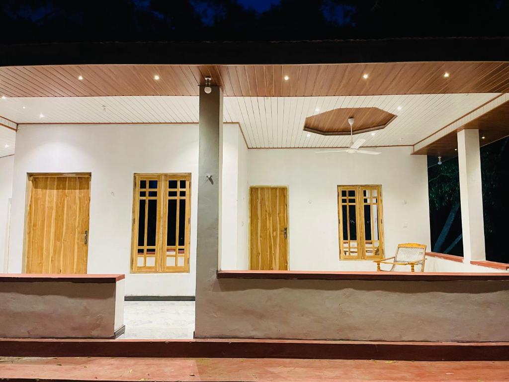 a house with a bench in front of it at Lotus Green Hotel And Restaurant in Arugam Bay