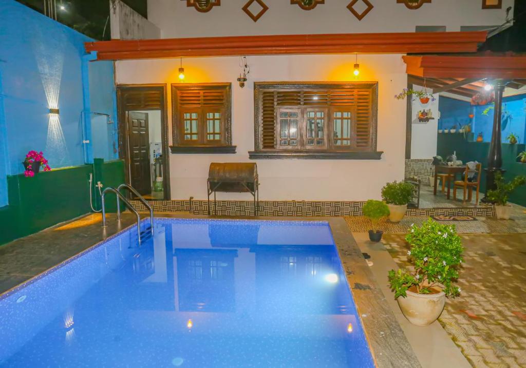 a large swimming pool in a room with a house at Sajee Villa in Hikkaduwa