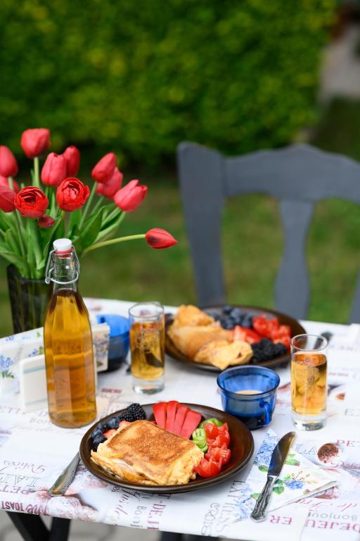 a table with plates of food and flowers on it at DowntownKate in Debrecen