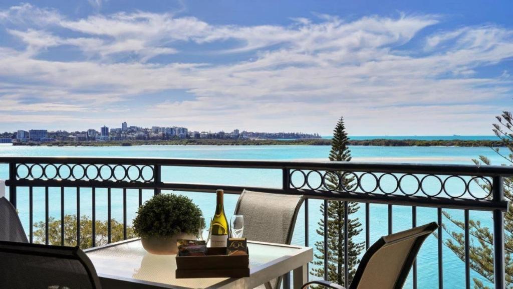 a balcony with a table and a view of the water at #812 Ramada Resort, Beachfront in Golden Beach