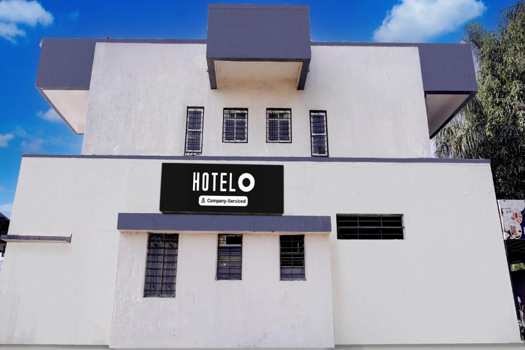a white building with a hotel sign on it at Hotel O Satara Bypass Formerly Sairaj Lodging in Satara