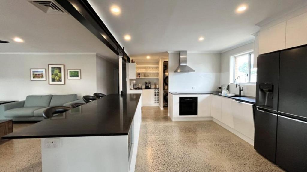 a kitchen and living room with a black counter top at Beachside Bliss In The Crown in Kawana Waters