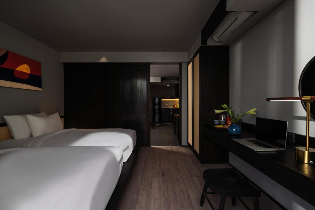A bedroom with two single beds and a dedicated laptop desk.